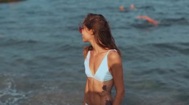 Ağır çekimde beyaz bikinili güzel ve çekici bir kadın.