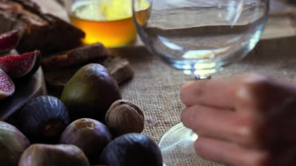 Assortment of cheeses, glass red wine, figs, honey, nuts and bread — Stock Video