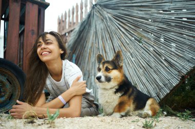 Neşeli, kaygısız bir kadın, komik bir Galli Corgi köpeğiyle yatıyor, başka tarafa bakıyor ve hayatı emrediyor.
