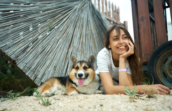 Pemilik wanita positif dengan anjing welsh corgi nya berbaring bersama-sama dan merasa baik, konsep hidup lambat — Stok Foto