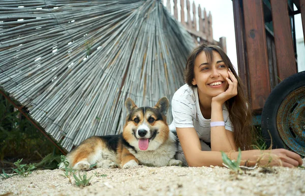 Positieve vrouwelijke eigenaar met haar huisdier welsh corgi hond liggen samen en zich goed voelen, concept langzaam leven Rechtenvrije Stockfoto's