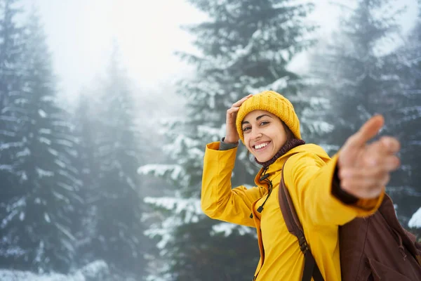 겨울 안개낀 숲 속의 여행객 여성이 카메라를 들고 저를 따라오듯이 손을 잡고 있습니다 — 스톡 사진