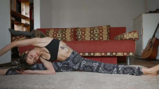 Mulher flexível faz alongamento no apartamento — Vídeo de Stock