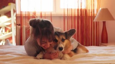 Sevdiği köpeği Galli Corgi ile yatakta yatan mutlu kadının yakın plan portresi..