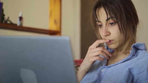 Concerned woman working on laptop computer at home — Stock Video