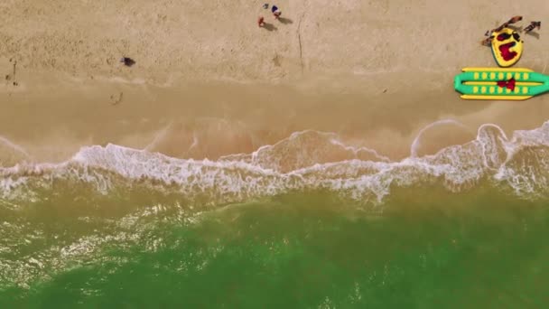 Vanuit de lucht naar de zandkust met resorts, parasols en attracties op het strand. — Stockvideo