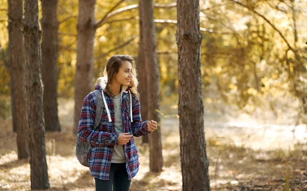 Viajera en un bosque soleado sola. Mochilero chica disfrutando de caminar al aire libre — Foto de Stock