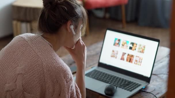 Visão traseira jovem mulher com fones de ouvido sem fio e laptop — Vídeo de Stock