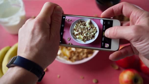 건강 한 아침 식사 사진을 전화기로 찍고 있는 남자 — 비디오