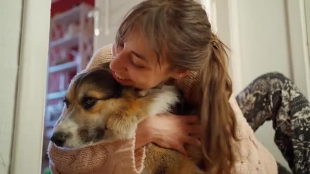 Vreugdevolle tedere vrouw zit op de vloer met hond, knuffelen en aaien hem — Stockvideo