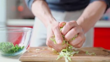 Aşçı kesilmiş lahanayı tahtadan şeffaf cam kaseye koyar.