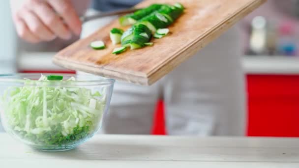 Cuire met le concombre coupé du placard en bois au bol en verre transparent — Video