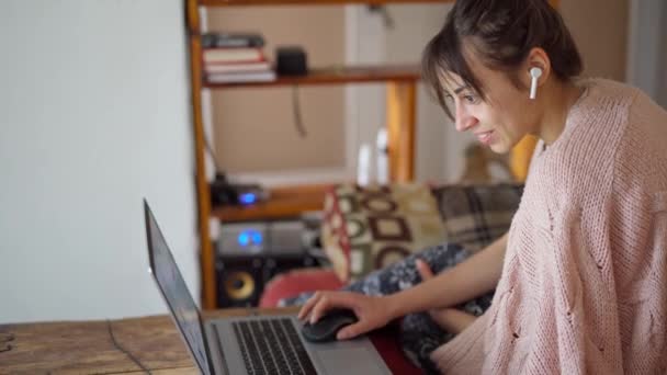 Mulher com fones de ouvido sem fio e laptop — Vídeo de Stock