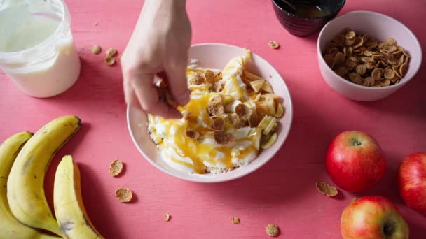 Lägga till flingor till sallad från keso, yoghurt, frukt och honung — Stockvideo