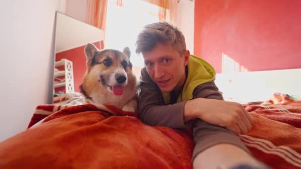 Man neemt selfie met hond in slaapkamer — Stockvideo