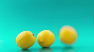 Turkuaz arka planda birbiri ardına düşen limonlar