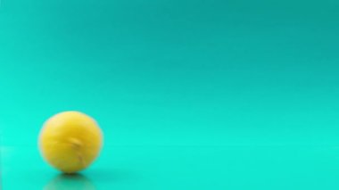 Turkuaz arka planda birbiri ardına limonlar yuvarlıyoruz.