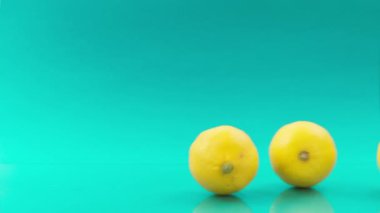 Turkuaz arka planda birbiri ardına limonlar yuvarlıyoruz.