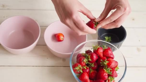 Жіночі руки очищають полуницю — стокове відео