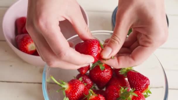 Tätt ihop kvinnliga händer skalar jordgubbar — Stockvideo