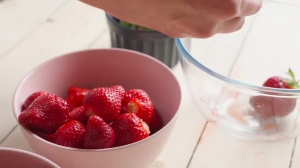 Fermer les mains féminines met des fraises dans des bols — Video