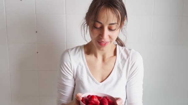 女性はイチゴとボウルを持ちベリーを食べる — ストック動画