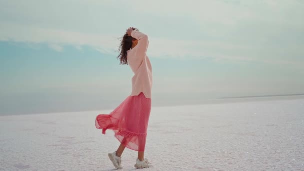 Mujer en suéter de gran tamaño con los brazos abiertos disfrutando de la naturaleza paisaje de sal plana en el lago Sasyk-Sivash — Vídeos de Stock