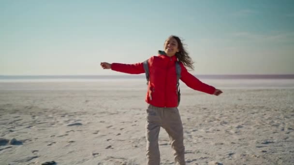 Slow motion fri glad ung vandrare kvinna i röd jacka skrattar och virvlande med upphöjda armar — Stockvideo
