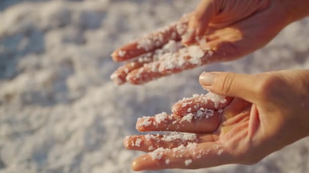 Vrouwen hand met gekristalliseerde zoutvlokken natuurlijke minerale vorming — Stockvideo