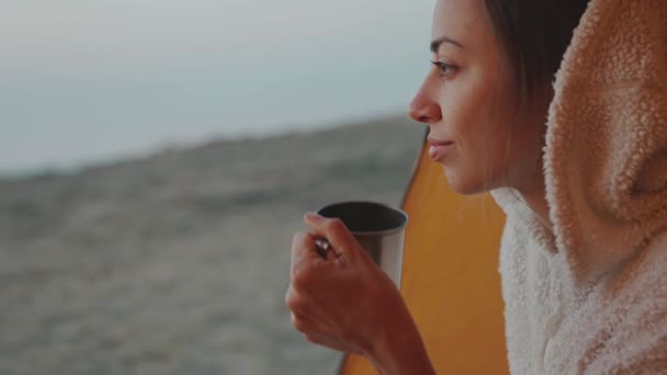 自信満々の美人がテントに座りマグカップを手にコーヒーを持って. — ストック動画