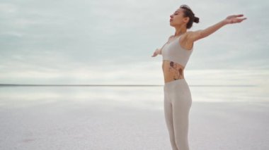 Tozluklu, ince bir kadın, meditasyon yapıyor ve dışarıda yoga yapıyor.