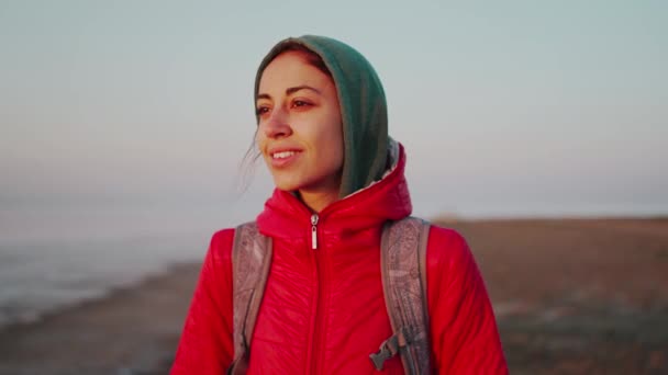 Młoda kobieta podróżnik z plecakiem spotkanie wschód słońca na bezludnej plaży morskiej — Wideo stockowe