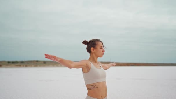 Steadycam camera moving around Yoga woman practices at beach working out and relaxing outside on beach at sunrise — Stock Video