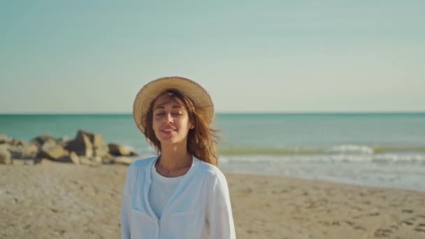 Porträt einer schönen, stilvollen Reisenden, die entlang der Küste wandert und den Sonnenuntergang am Meer genießt. — Stockvideo