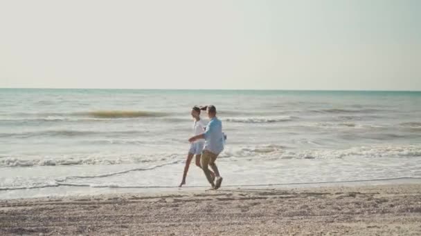 Gelukkig mooi paar hebben plezier lopen langs zandstrand samen — Stockvideo