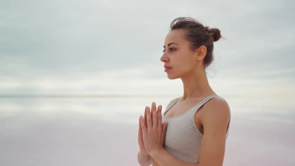 Krásná štíhlá žena v legíny a horní meditace a cvičení jógy venku — Stock video
