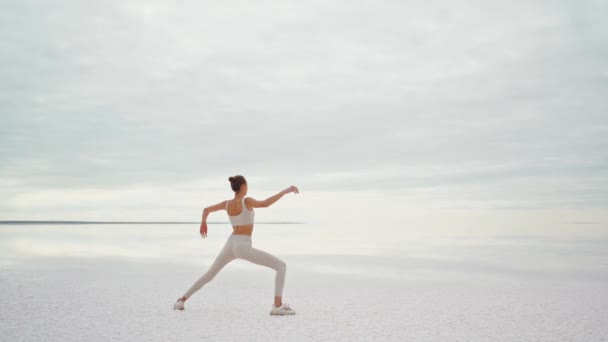 Állandó kamera mozgó körül jóga nő gyakorlatok a strandon edzés és pihentető kívül strandon napkeltekor — Stock videók