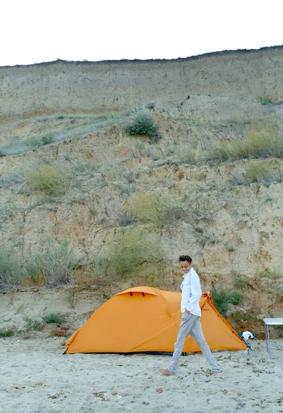 Sommerjente som går på sandstrand nær teltet, nyter livet på ferie – stockfoto