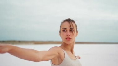 Yoga yapan kadın plajda antrenman yapıyor ve gün doğumunda plajda dinleniyor.