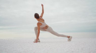 Zayıf esmer kadın temiz havada yoga yapıyor. Kadın tuz gölü çölünde yoga yapıyor. Kadın dışarıda yoga yapıyor..