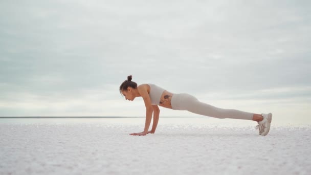 Fiatal vonzó nő csinál testtartások Sun Salutation jóga sorozat a természetben: deszka, felfelé és lefelé néző kutya pózol. — Stock videók