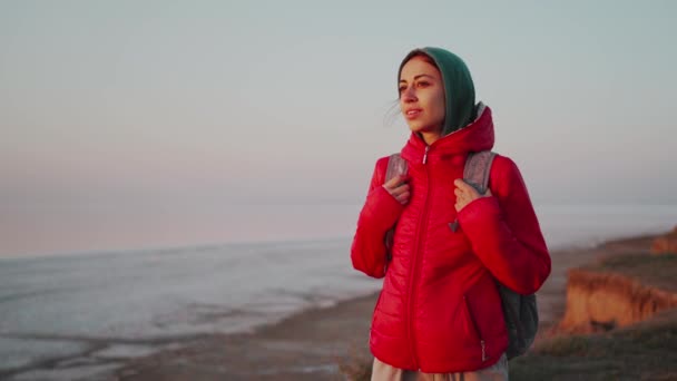 Fiatal nő utazó hátizsák találkozó napkelte az elhagyatott tengerparton — Stock videók