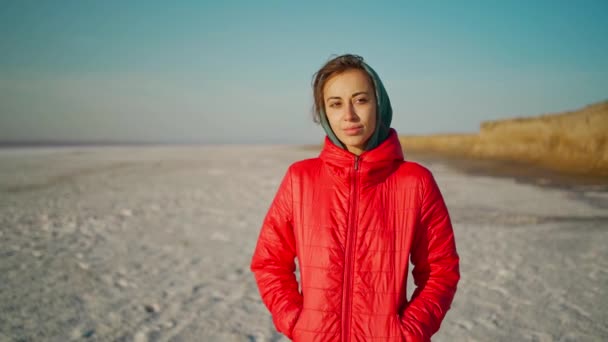 Rallentatore bella donna mista corsa escursionista in felpa con cappuccio a piedi lungo ampia spiaggia bianca all'alba. — Video Stock