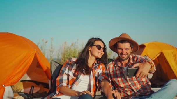 행복 한 매력적 인 가족 여행자들이 해변 의자에 앉아 키스를 하고 셀카를 전화로 받는 모습. — 비디오
