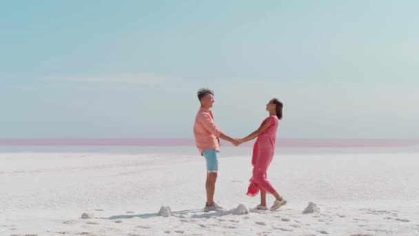 Casal elegante elegante andando na costa salgada branca parece deserto, férias de lua de mel — Vídeo de Stock