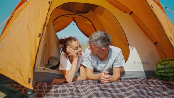 Mutlu otantik anlar. Kamp gezisinde bir çift, çadırda birlikte yatıyorlar. — Stok video