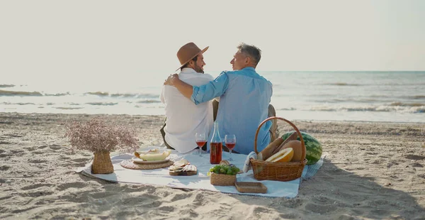 Homosexual lgbt couple, gay men having picnic at the beach Royalty Free Stock Images