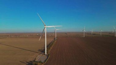 Geniş rüzgar türbinleri. Sahada bıçakları var. Parlak gün doğumu..