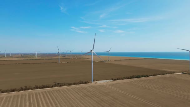 美しい明確な朝の農村部の海辺の風景の上に風力タービンファーム。緑の生態系の世界のための再生可能エネルギー生産. — ストック動画