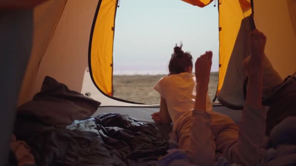 Cute szczęśliwy autentyczne chwile dziewczyna w kempingu podróży wakacje. Zwykła kobieta leżąca w namiocie. — Wideo stockowe